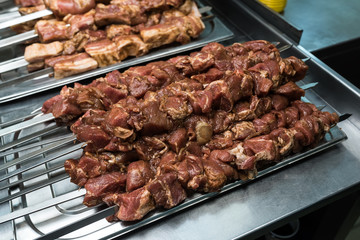 Raw meat on skewers in the kitchen