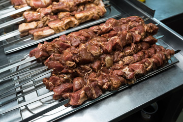 Raw meat on skewers in the kitchen