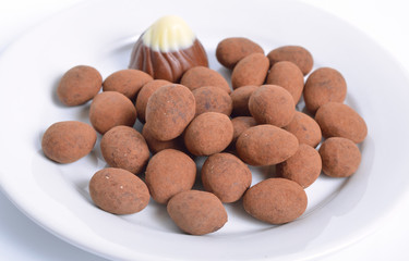 Sweets with almonds and cocoa powder. On white background