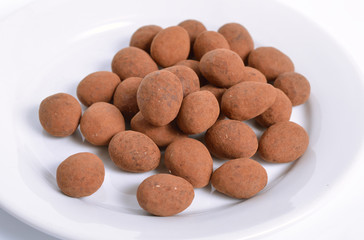Sweets with almonds and cocoa powder. On white background