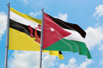 Jordan and Brunei flags waving in the wind against white cloudy blue sky together. Diplomacy concept, international relations.