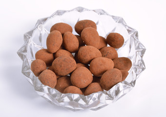 Sweets with almonds and cocoa powder. On white background