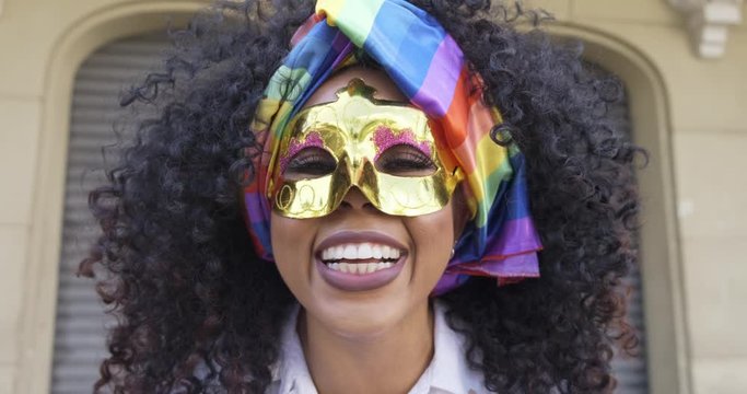 Carnaval party. Brazilian curly hair woman in costume blowing confetti. 4K.
