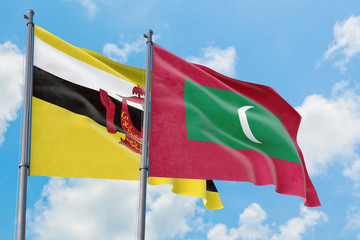 Maldives and Brunei flags waving in the wind against white cloudy blue sky together. Diplomacy concept, international relations.