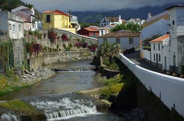 Fototapeta na wymiar Cascade river going through cozy city, beautiful view of Sao Miguel island, Azores