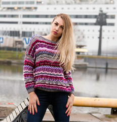  Woman posing in a striped knit burgundy sweater, handmade knitted clothes