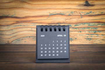 2020 April. Black paper calendar on a wooden table