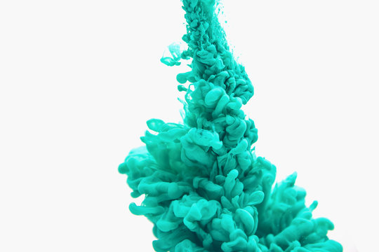 An abstract form of mint or aqua menthe colored ink in water on a white background in motion or action with no gravity style