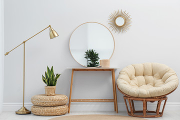 Stylish round mirror near white wall in room