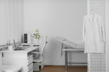 Doctor's office interior with desk and examination couch