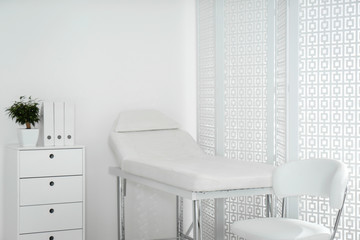 Examination room with modern couch and folding screen in clinic