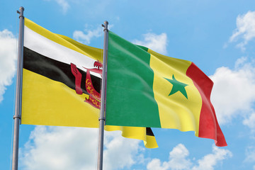 Senegal and Brunei flags waving in the wind against white cloudy blue sky together. Diplomacy concept, international relations.