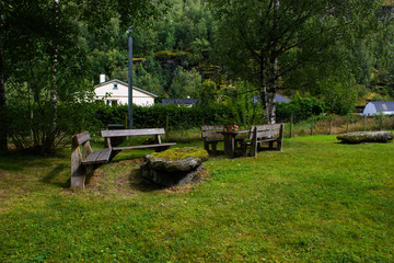 Obraz na płótnie Canvas Cozy park with wooden benches and a stone table in Norway