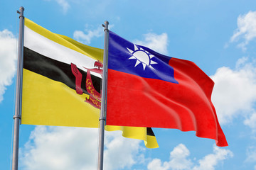 Taiwan and Brunei flags waving in the wind against white cloudy blue sky together. Diplomacy concept, international relations.