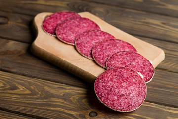 chopped sausage with spices on a wooden board