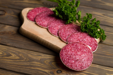 chopped sausage with spices on a wooden board