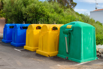 A row of colorful dustbins for waste segregation.