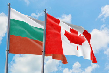 Canada and Bulgaria flags waving in the wind against white cloudy blue sky together. Diplomacy concept, international relations.