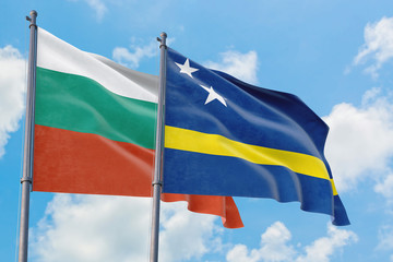 Curacao and Bulgaria flags waving in the wind against white cloudy blue sky together. Diplomacy concept, international relations.