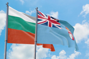 Fiji and Bulgaria flags waving in the wind against white cloudy blue sky together. Diplomacy concept, international relations.