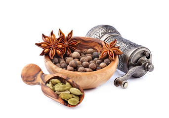Pepper black with cardamom and anise  in wooden bowl on white background.