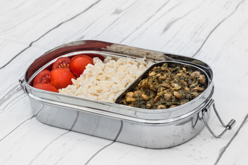 Rice and lentils Indian meal (Dal chawal) in tiffin on light background