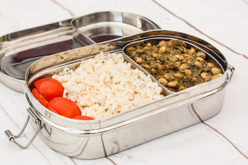Rice and lentils Indian meal (Dal chawal) in tiffin on light background