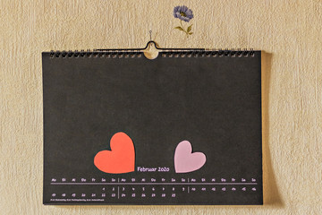 Calendar on the wall for February with hearts made of paper and marked with the date-February 14th. Valentine's Day.