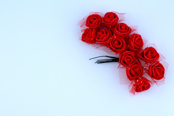 Beautiful red bouquet of small roses lies on a clean white sheet of paper