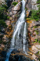 France. Lozère. Une cascade d'un ruiseau sur des rochers rouge.