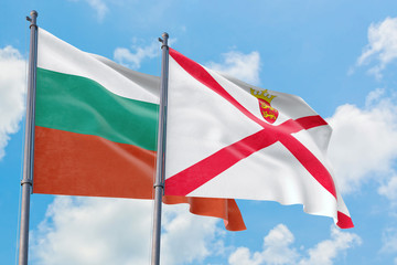 Jersey and Bulgaria flags waving in the wind against white cloudy blue sky together. Diplomacy concept, international relations.