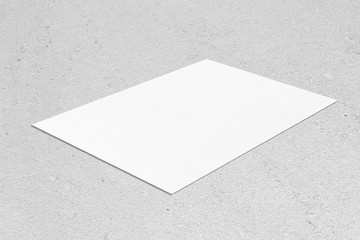 Closeup of empty white rectangle horizontal poster mockup lying diagonally on neutral grey concrete...