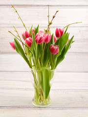Tulips in vase. White and red spring flowers on wooden background. Bouguet of tulips.