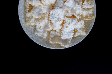 Frappe di carnevale, dessert italiano cucinato a febbraio, sul piatto bianco e fondo di marmo,...