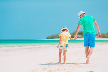 Fototapeta na wymiar Little girl and happy dad having fun during beach vacation
