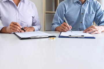 Young couple in the courthouse filing pen to signing divorce papers or premarital agreement, deciding on marriage divorce concept