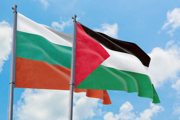 Palestine and Bulgaria flags waving in the wind against white cloudy blue sky together. Diplomacy concept, international relations.
