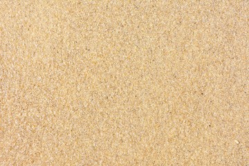 Golden sand background with selective focus. Textured yellow sand surface with soft focus....