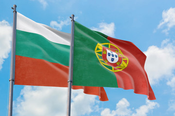 Portugal and Bulgaria flags waving in the wind against white cloudy blue sky together. Diplomacy concept, international relations.