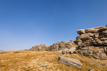 granite rocks at Great Mis Tor, Dartmoor National Park, Devon on a sunny day with blue sky