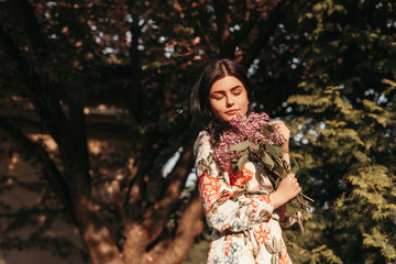Young woman smelling flowers in park