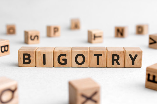 Bigotry - words from wooden blocks with letters, disliking other people bigotry concept, white background