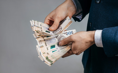 Businessman counts real money hryvnia in hands