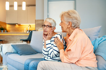 Senior woman comforts her friend supporting her in difficult time showing love attention and care,...