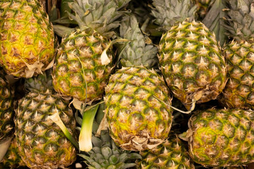 Lots of pineapple fruit background top view, tropical fruits in supermarkets.