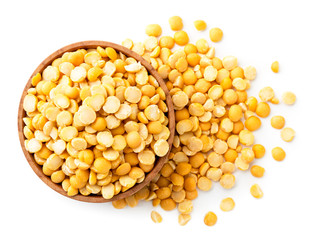 Yellow peas in a wooden plate and scattered on a white. The view of the top.