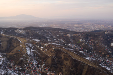 Aerial drone shot of Brasov historical neighborhood Schei at sunset on a beautiful winter day