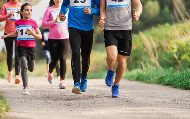 Midsection of large group of people running a race competition in nature.