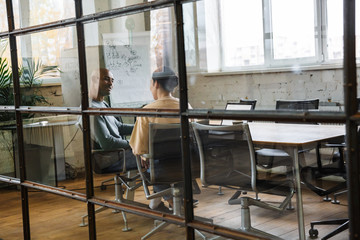 Image of multiethnic young coworkers working on laptops in office