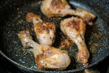 the golden chicken legs fried in a frying pan